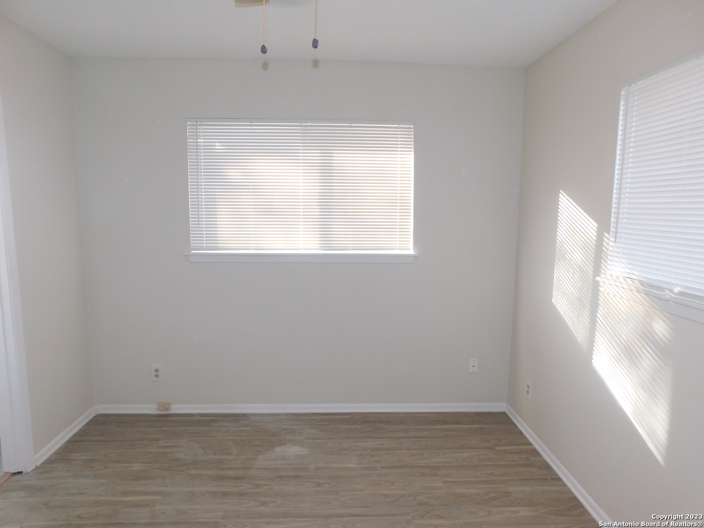 923 Spring Park Drive San Antonio, TX 78227 - Photo 17 of 30 an empty room with wooden floor and windows