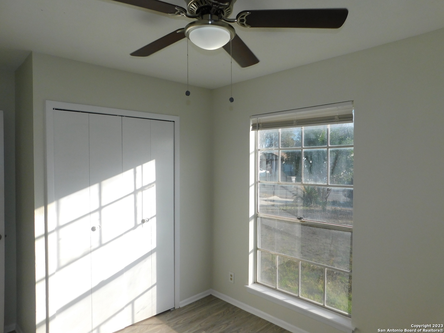 923 Spring Park Drive San Antonio, TX 78227 - Photo 24 of 30 an empty room with wooden floor chandelier fan and windows