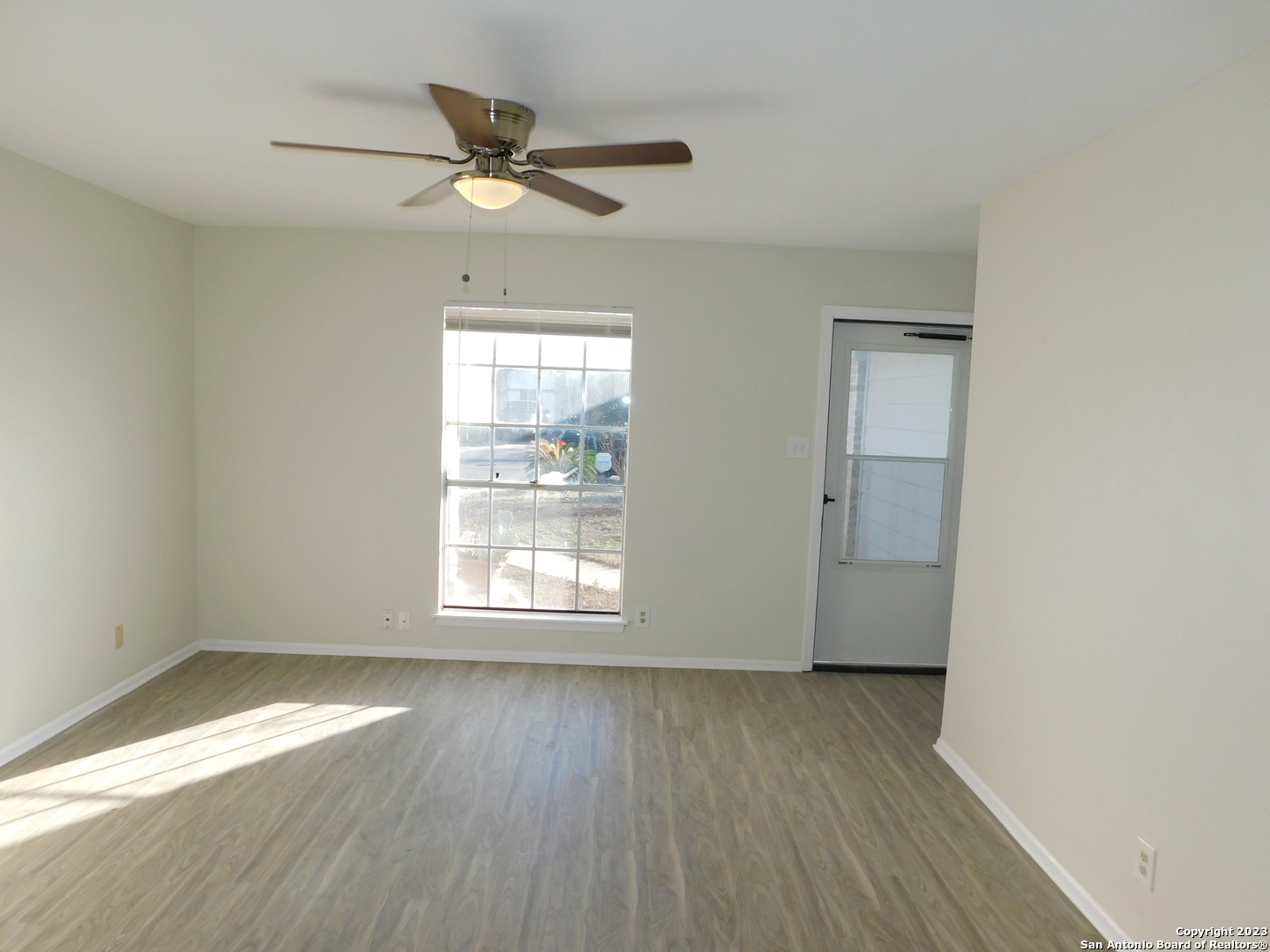 923 Spring Park Drive San Antonio, TX 78227 - Photo 3 of 30 an empty room with wooden floor fan and windows