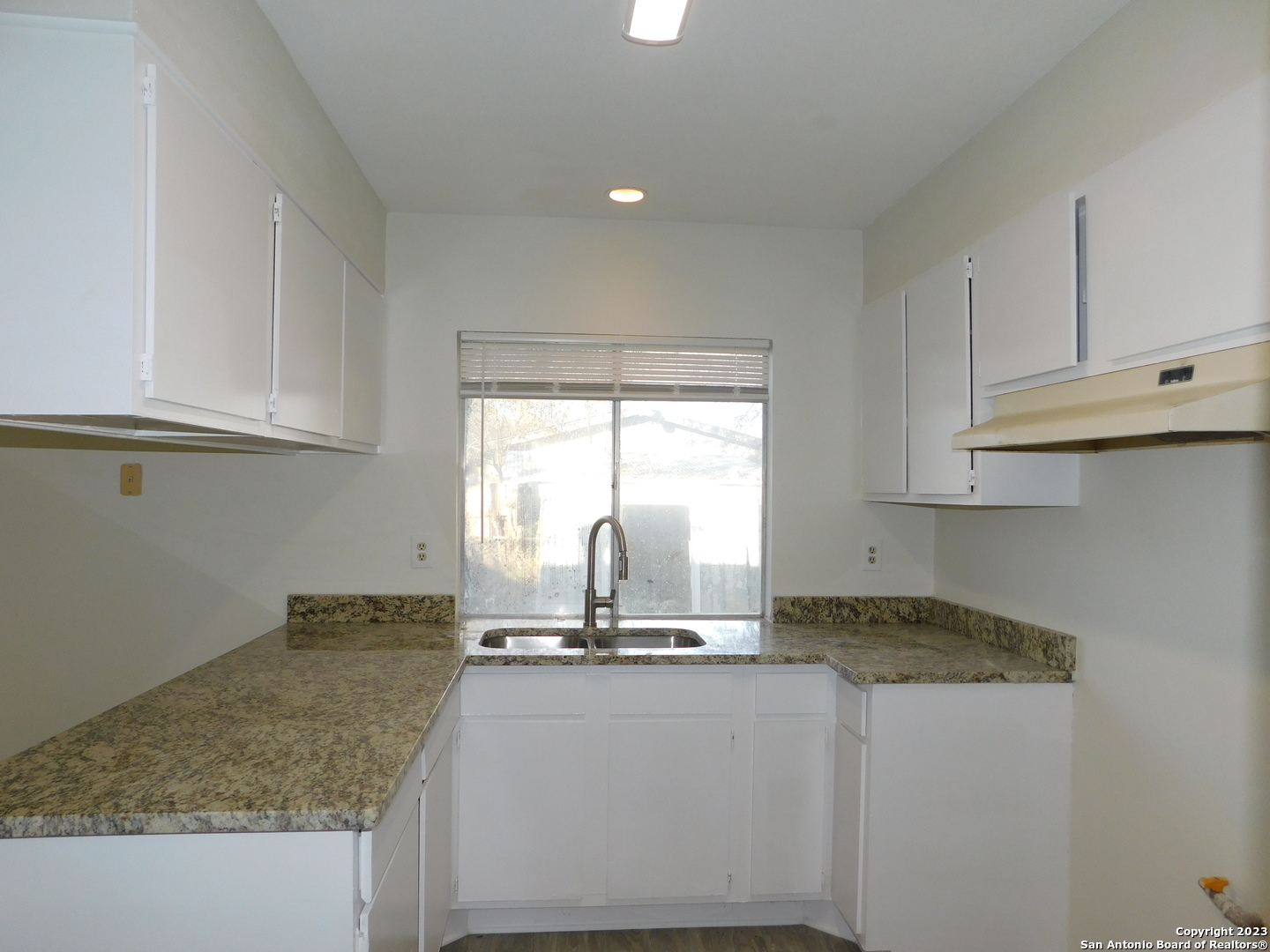 923 Spring Park Drive San Antonio, TX 78227 - Photo 9 of 30 a kitchen with granite countertop a sink stainless steel appliances white cabinets and a window