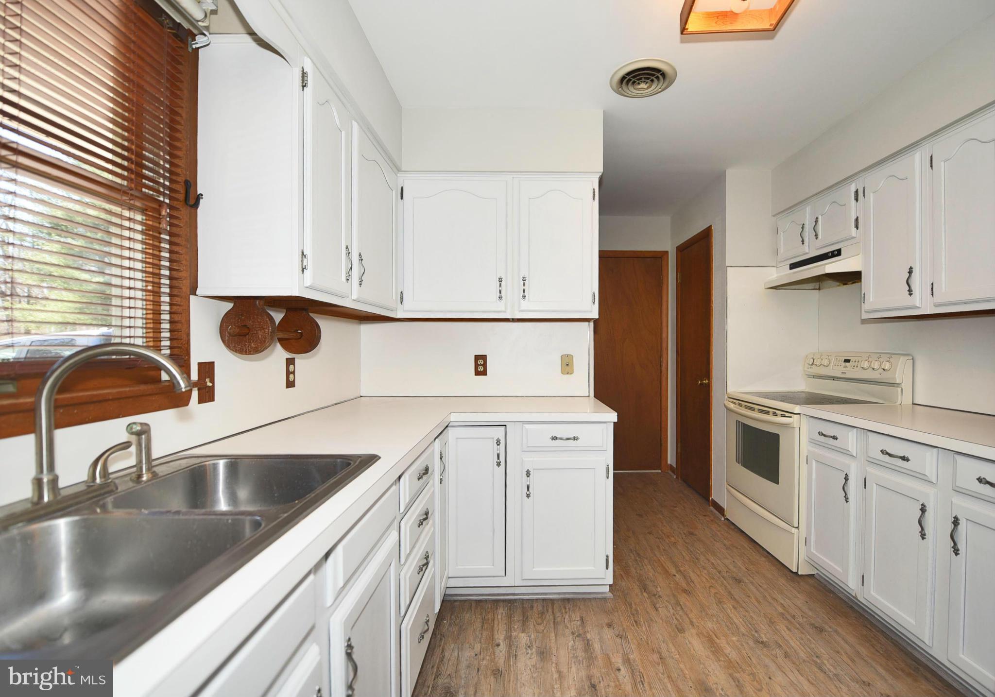 911 Ridge Road Rising Sun, MD 21911 - Photo 19 of 30 a kitchen with a sink white cabinets and white appliances