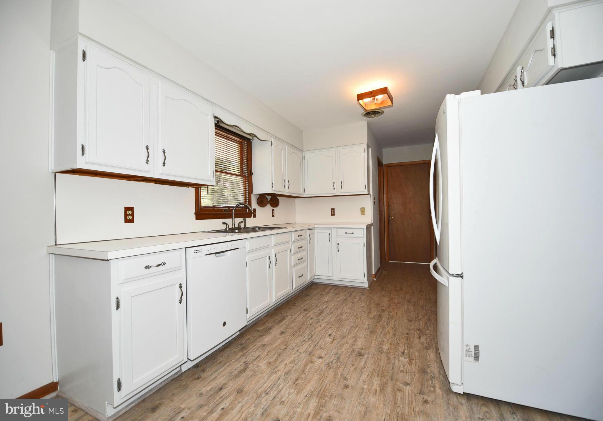 911 Ridge Road Rising Sun, MD 21911 - Photo 21 of 30 a kitchen with a refrigerator a sink and dishwasher with wooden floor