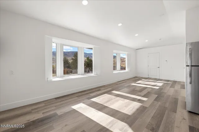 a view of empty room with wooden floor