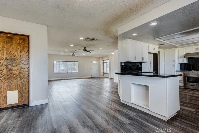 a view of kitchen with microwave a stove and wooden floor