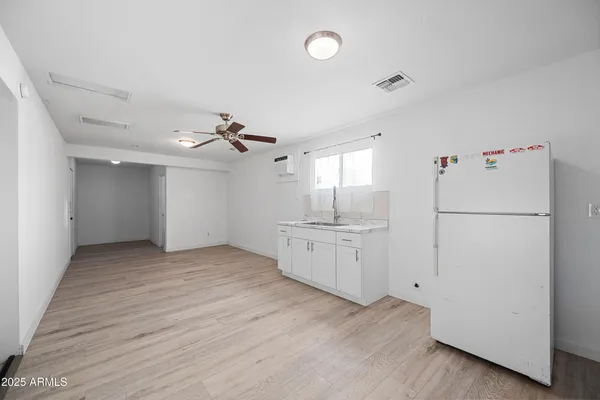 a view of a kitchen with a white cabinet and a refrigerator