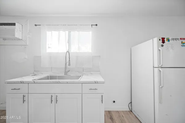 a kitchen with a sink refrigerator and window