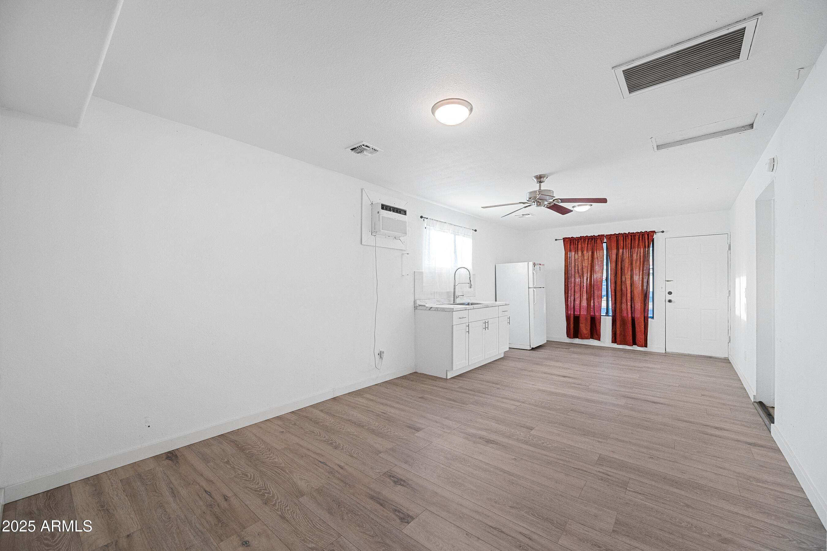 2057 East 10th Street Tempe, AZ 85281 - Photo 21 of 26 a view of an empty room with window and wooden floor