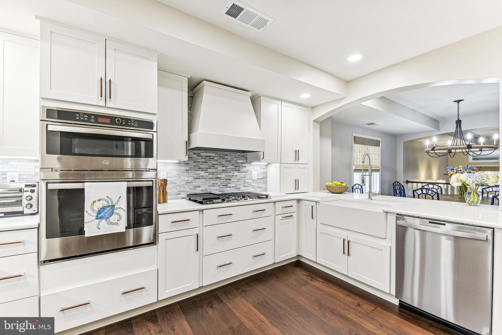a kitchen with cabinets stainless steel appliances and wooden floor