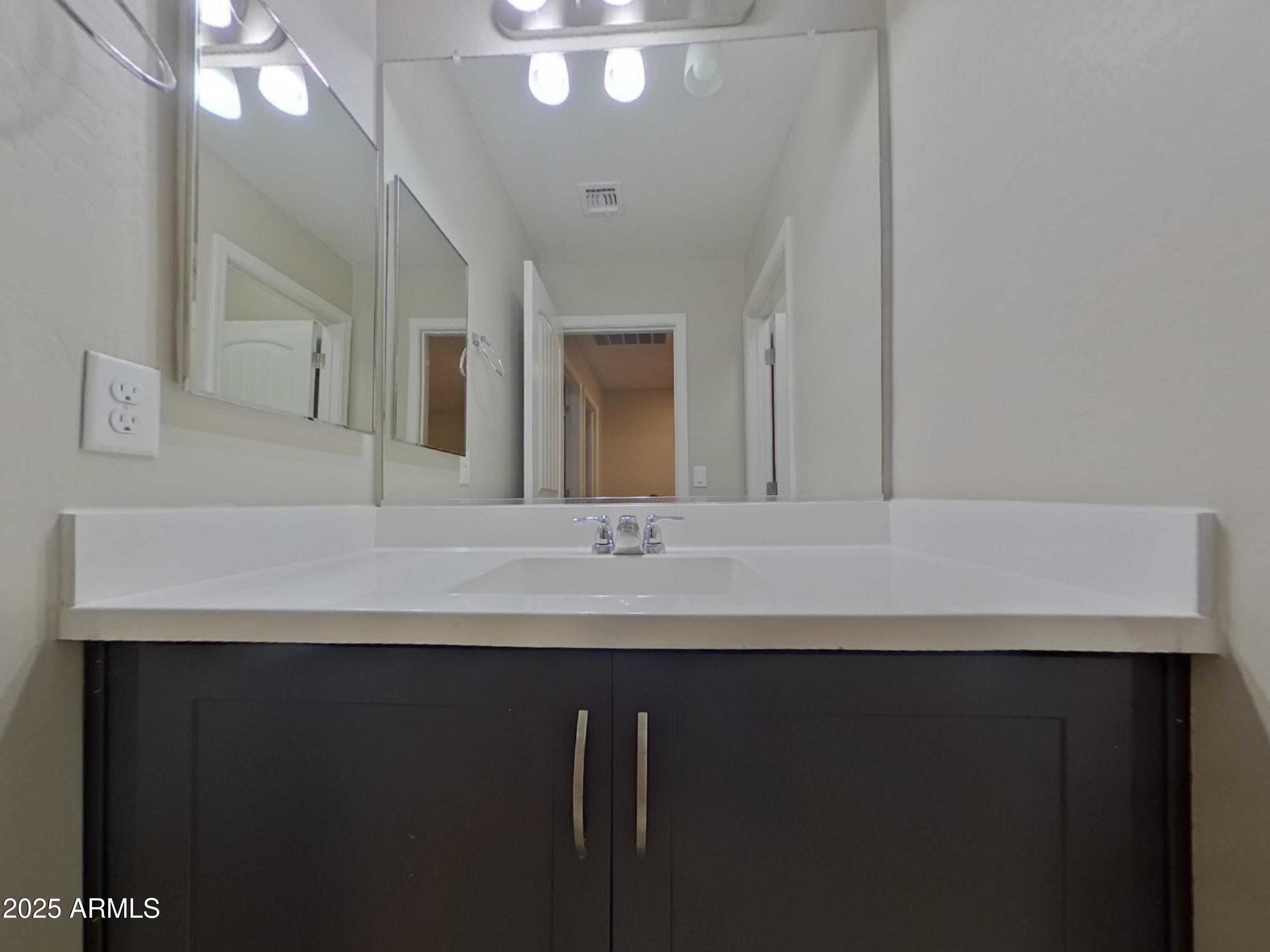 12578 West Steed Ridge Peoria, AZ 85383 - Photo 14 of 17 a bathroom with a sink a large mirror and a toilet