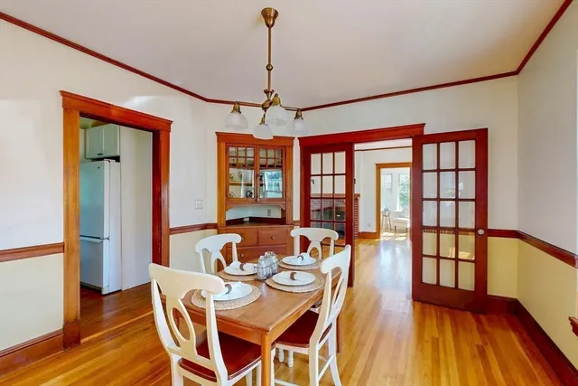 a dining room with furniture a chandelier and wooden floor