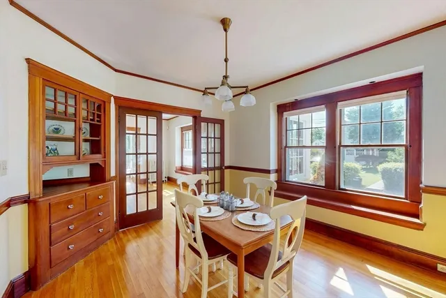 a dining room with furniture a chandelier and wooden floor