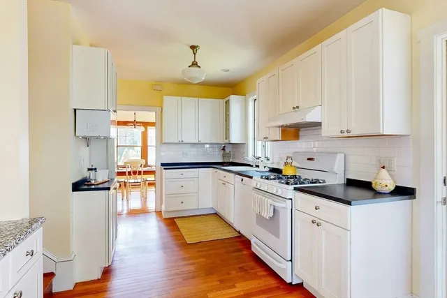 a kitchen with granite countertop white cabinets and white appliances