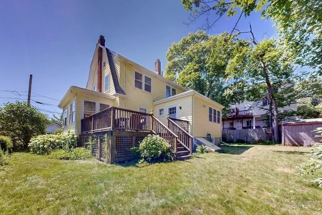 a front view of a house with a yard and potted plants