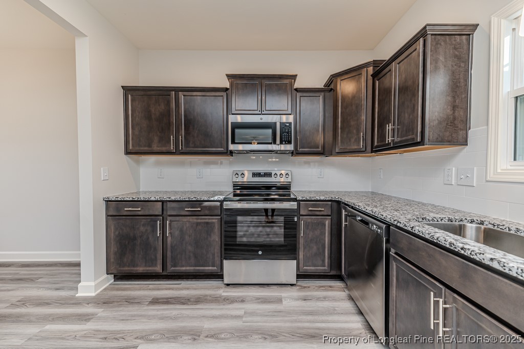 87 Onslow Court Spring Lake, NC 28390 - Photo 11 of 33 a kitchen with granite countertop stainless steel appliances and wooden cabinets