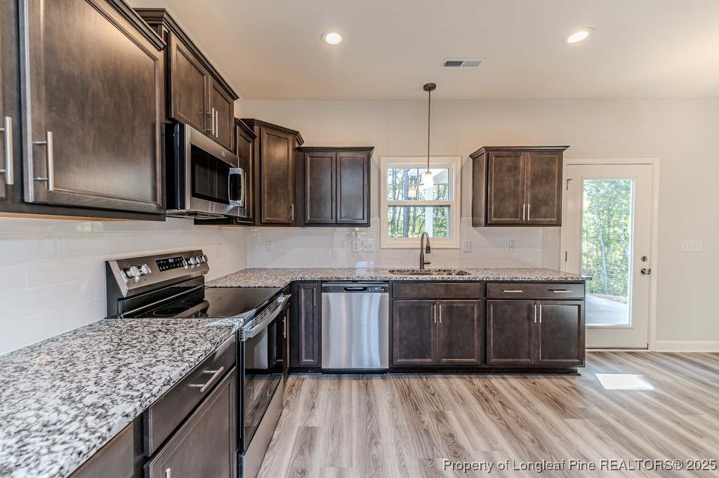 87 Onslow Court Spring Lake, NC 28390 - Photo 12 of 33 a kitchen with stainless steel appliances granite countertop wooden cabinets stove a sink and dishwasher