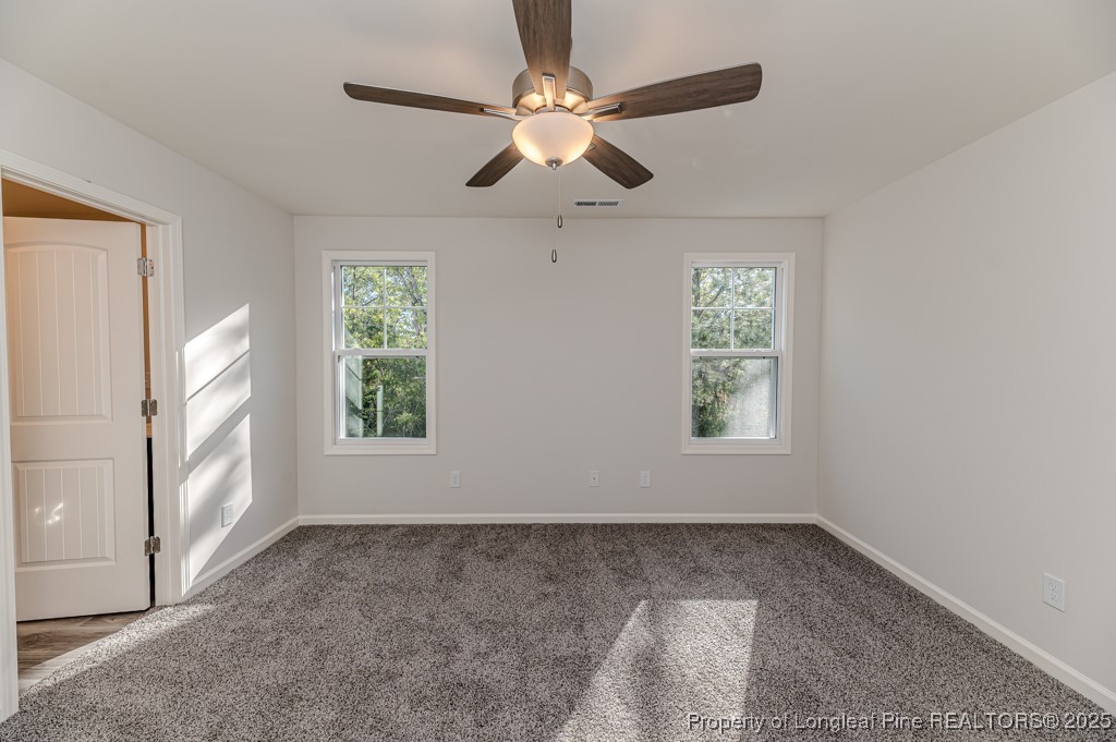 87 Onslow Court Spring Lake, NC 28390 - Photo 16 of 33 an empty room with windows and chandelier fan