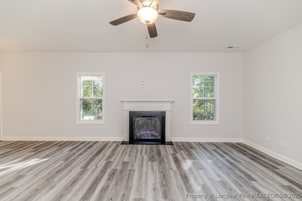 87 Onslow Court Spring Lake, NC 28390 - Photo 7 of 33 a view of an empty room with wooden floor fireplace and a window