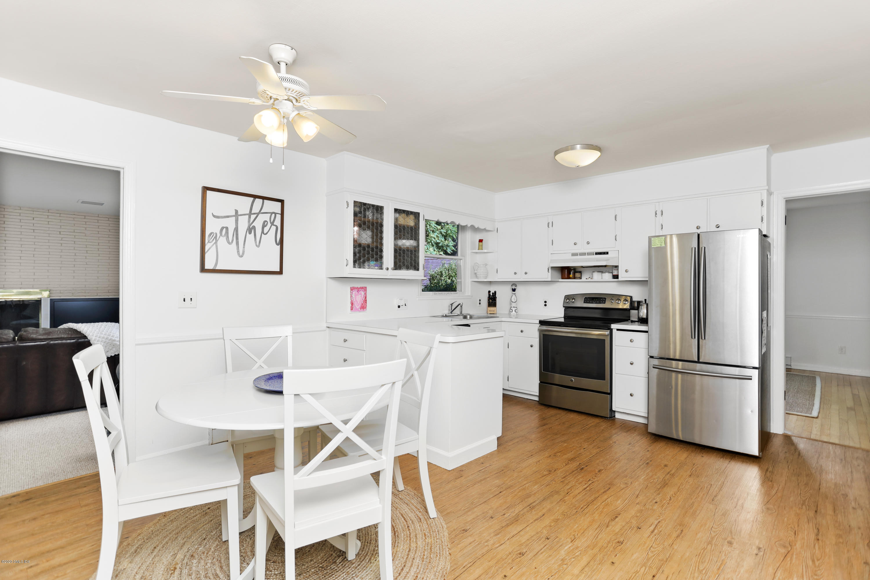 36 Butler Street Cos Cob, CT 06807 - Photo 4 of 12 a kitchen with stainless steel appliances kitchen island granite countertop a refrigerator a stove a sink dishwasher and a dining table with wooden floor