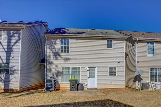 a view of a house with backyard and a tree