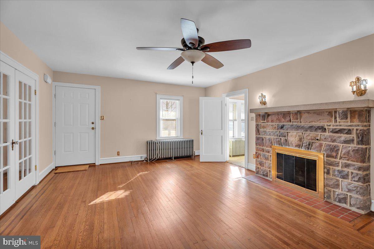 83 South Rte 73 Sicklerville, NJ 08081 - Photo 4 of 24 an empty room with wooden floor fireplace and windows