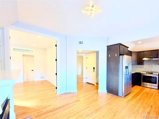 a kitchen with stainless steel appliances granite countertop a refrigerator a sink and a stove