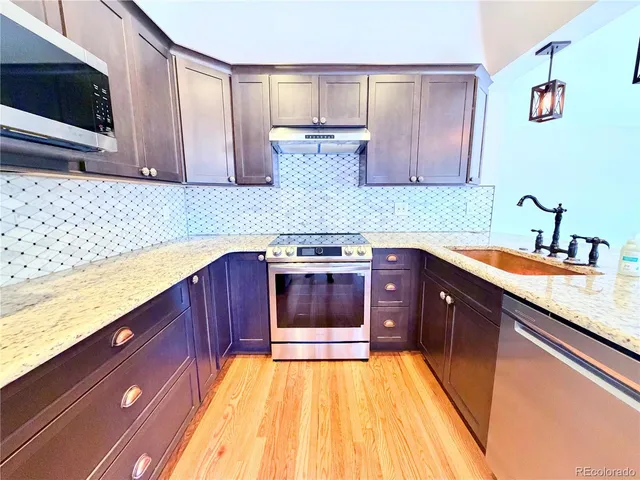 a kitchen with stainless steel appliances granite countertop a sink and a stove