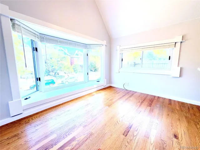 a view of kitchen and empty room with a fireplace