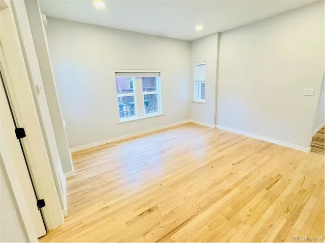 an empty room with wooden floor and a window
