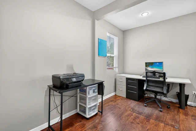 a view of a workspace with furniture and a window