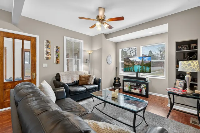 a living room with furniture a flat screen tv and a window
