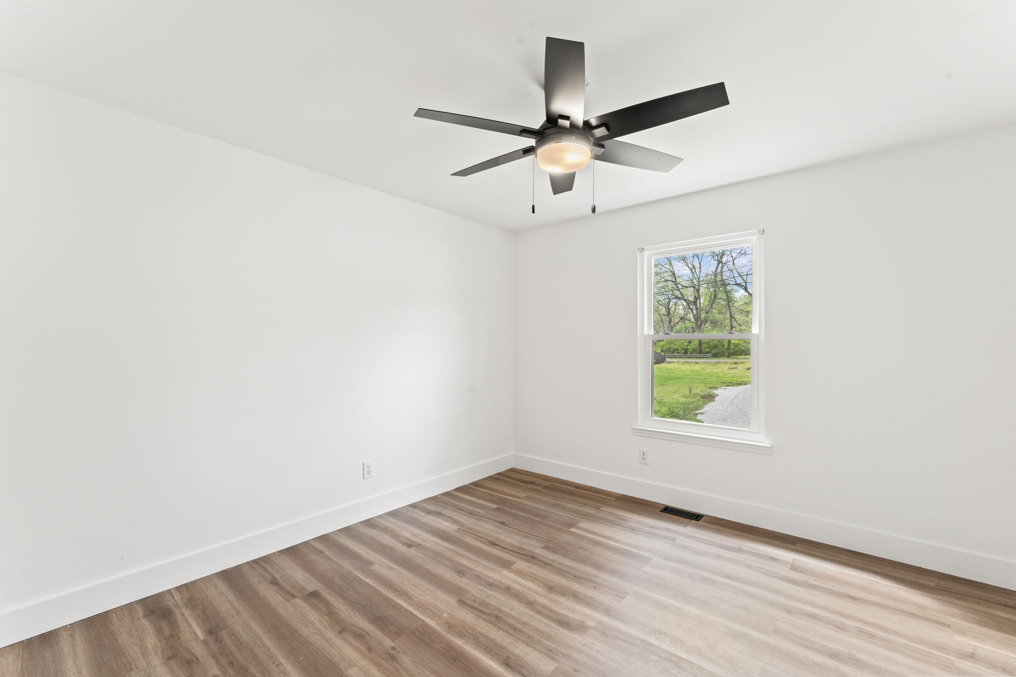 841 Neelys Bend Road Madison, TN 37115 - Photo 11 of 17 an empty room with wooden floor fan and windows