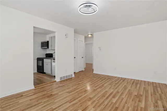 a view of empty room with wooden floor