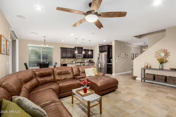 a kitchen with stainless steel appliances kitchen island granite countertop a refrigerator a stove a sink a dining table and chairs