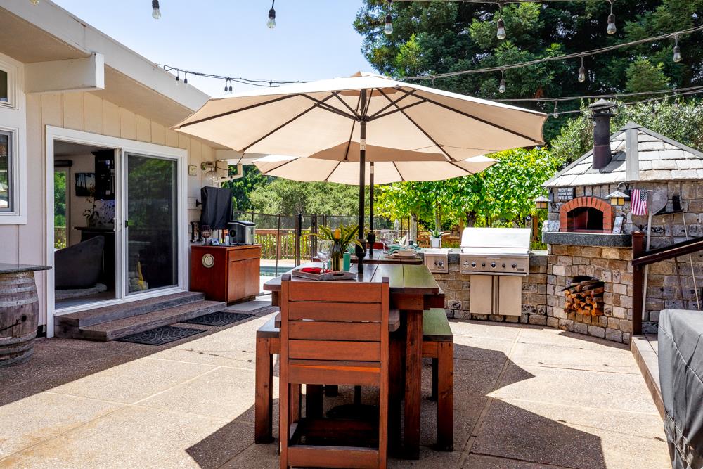 377 Brooktree Ranch Road Aptos, CA 95003 - Photo 28 of 50 a patio with a table and chairs under an umbrella