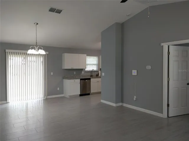 a view of a kitchen with a stove cabinets and a floor to ceiling window
