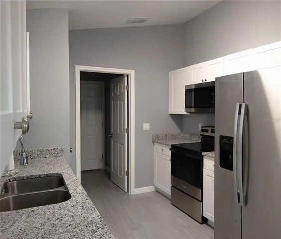 a kitchen with a refrigerator stove and sink