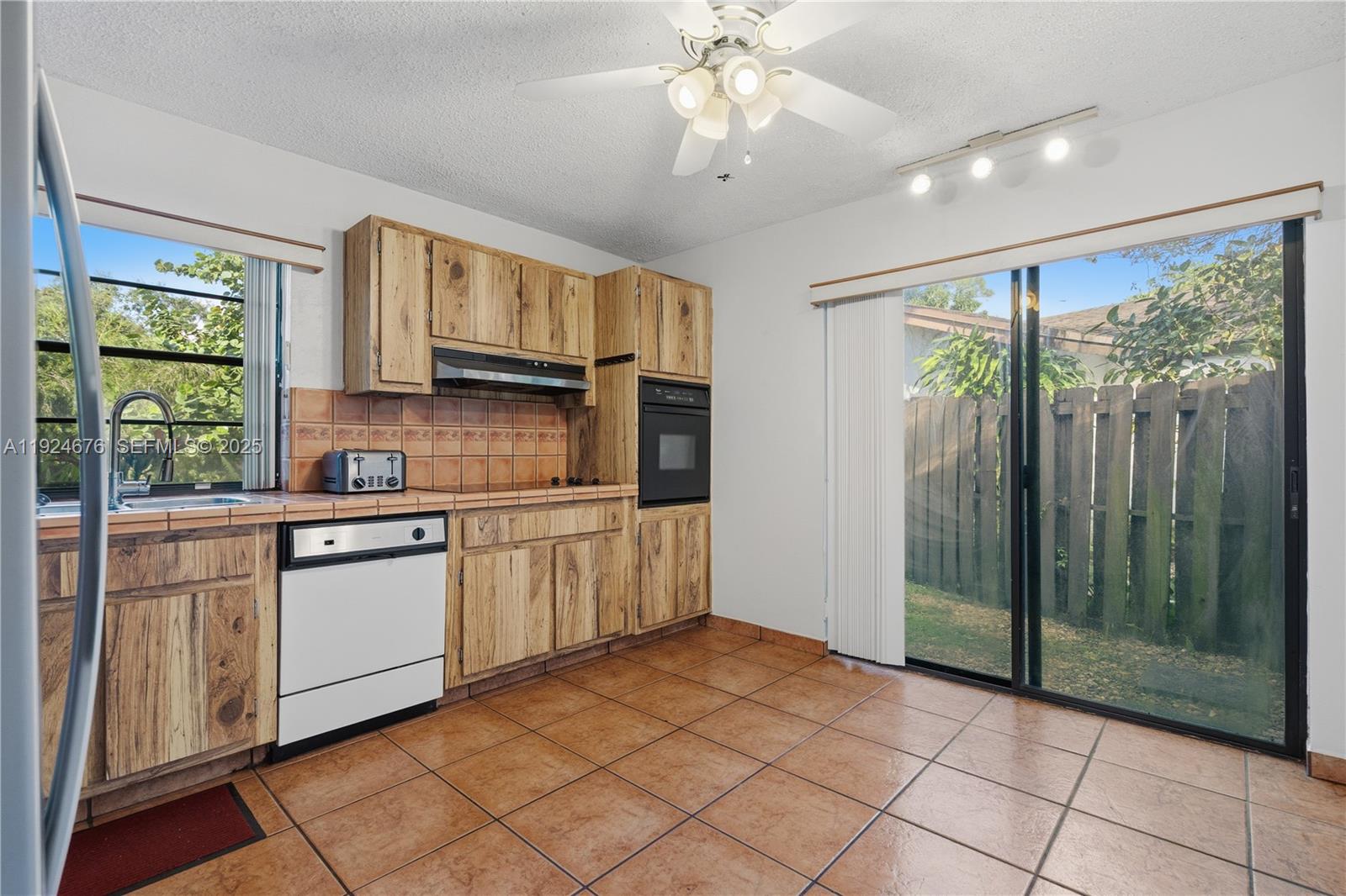 13585 Southwest 114th Terrace Miami, FL 33186 - Photo 12 of 42 a kitchen with stainless steel appliances granite countertop a refrigerator a sink dishwasher a stove and white cabinets with wooden floor