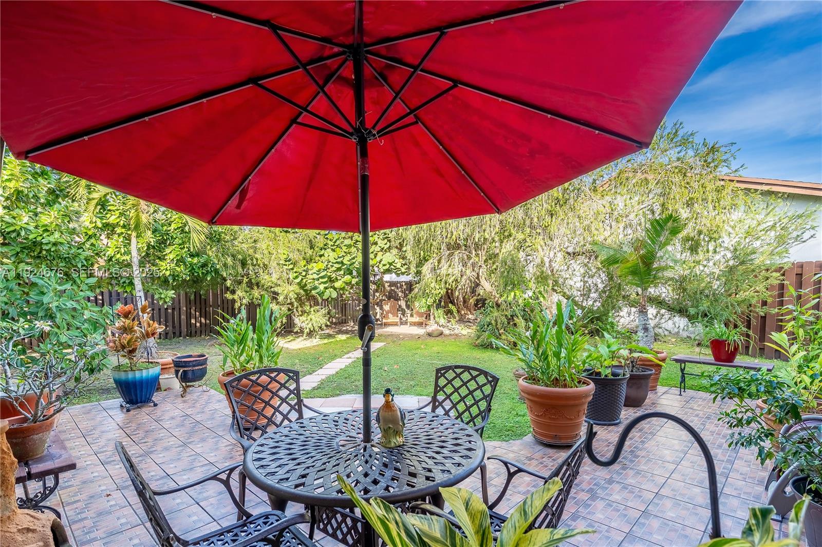 13585 Southwest 114th Terrace Miami, FL 33186 - Photo 34 of 42 a view of an outdoor sitting area with furniture and umbrella