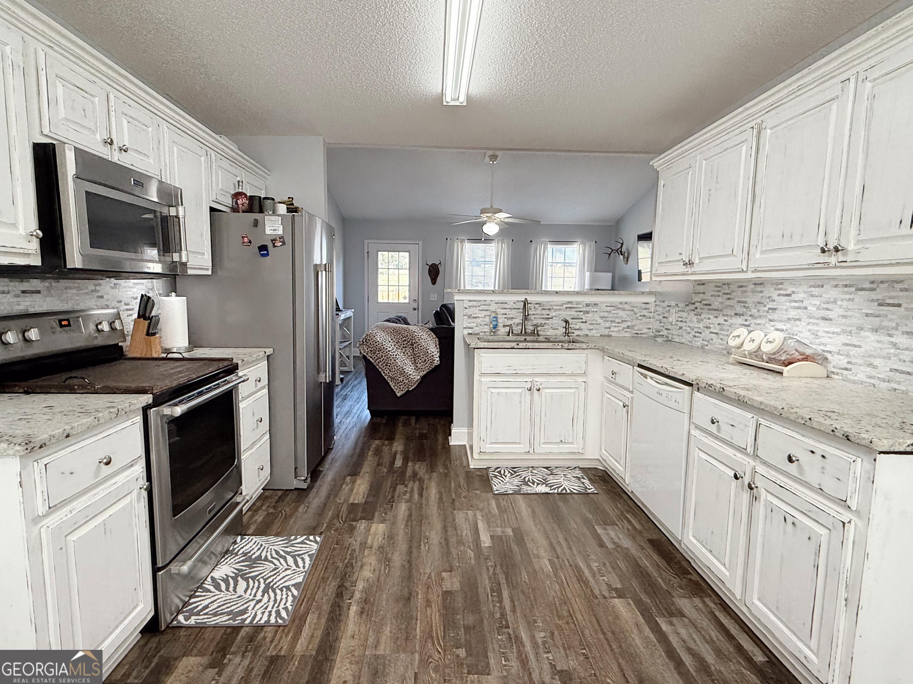 44 Quail Knoll Lane Cleveland, GA 30528 - Photo 12 of 42 a kitchen with granite countertop a refrigerator oven a sink dishwasher and white cabinets with wooden floor
