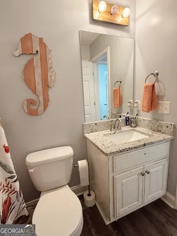 a bathroom with a granite countertop toilet sink and mirror