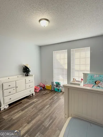 a kitchen with granite countertop a sink window and white cabinets