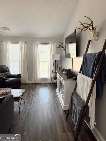 a living room with furniture and a wooden floor
