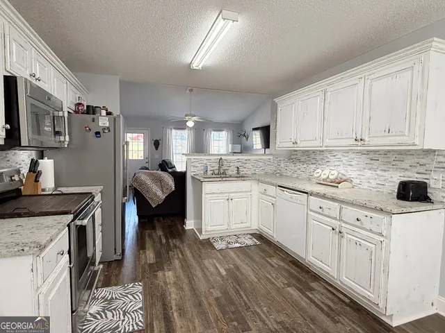 a kitchen with cabinets and wooden floor