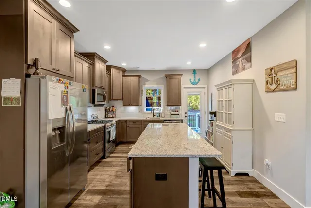 a living room with furniture kitchen view and a large window