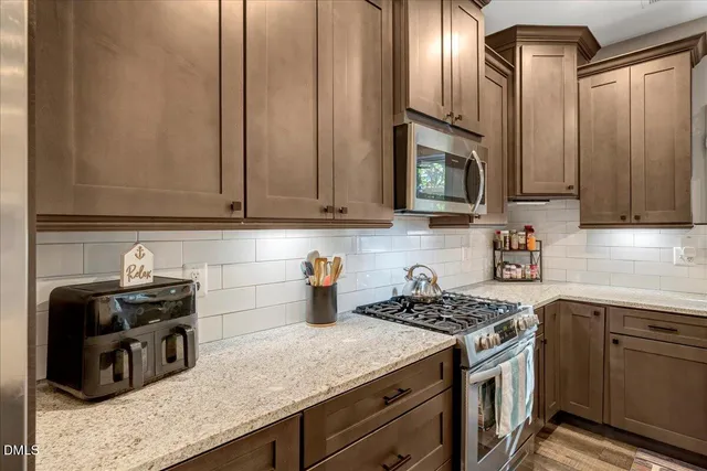 a living room with furniture a flat screen tv and a floor to ceiling window
