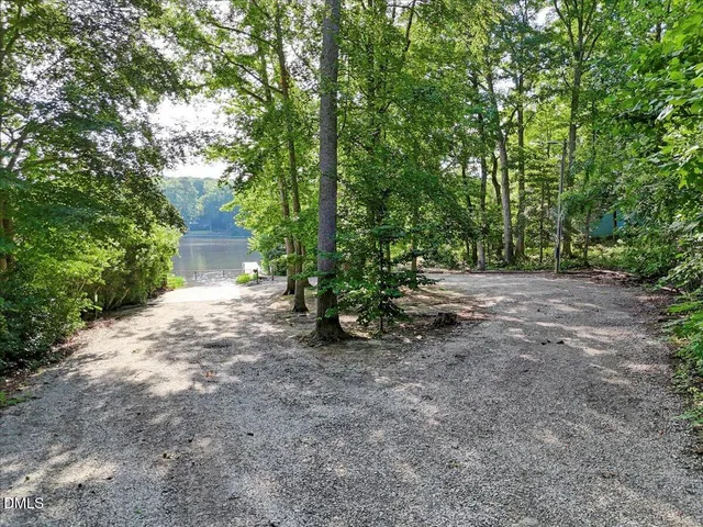a view of a dirt road with trees in the background
