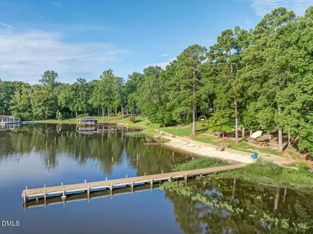 a front view of a house with a yard and lake view