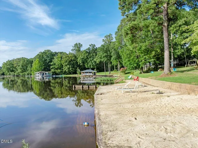 a view of a lake with a big yard and large trees