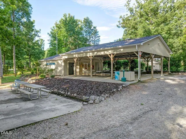 a view of a swimming pool with lawn chairs under an umbrella