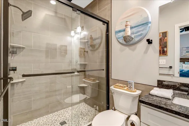 a bathroom with a granite countertop sink mirror vanity and toilet